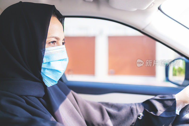 阿拉伯妇女驾驶戴口罩和手套- COVID-19系列